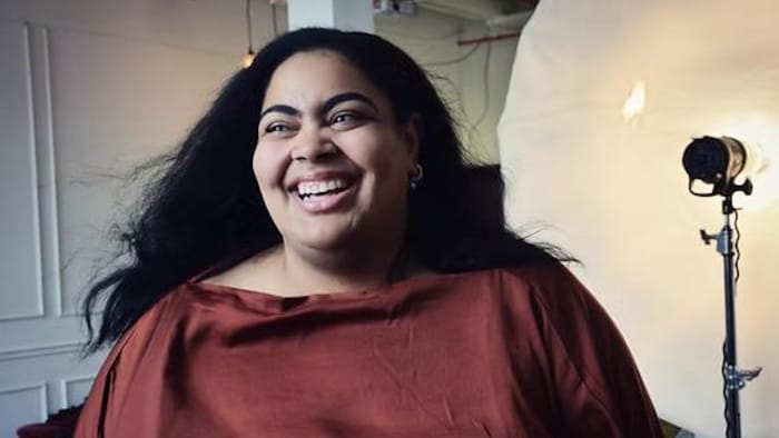 La femme sourit dans un workplace de photographie.