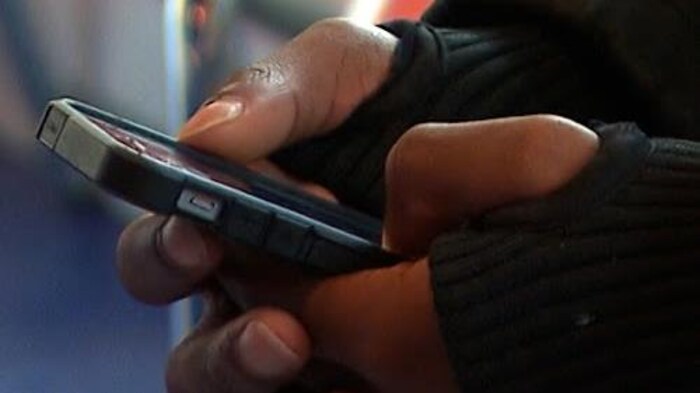 Une personne tient un téléphone intelligent dans sa main.