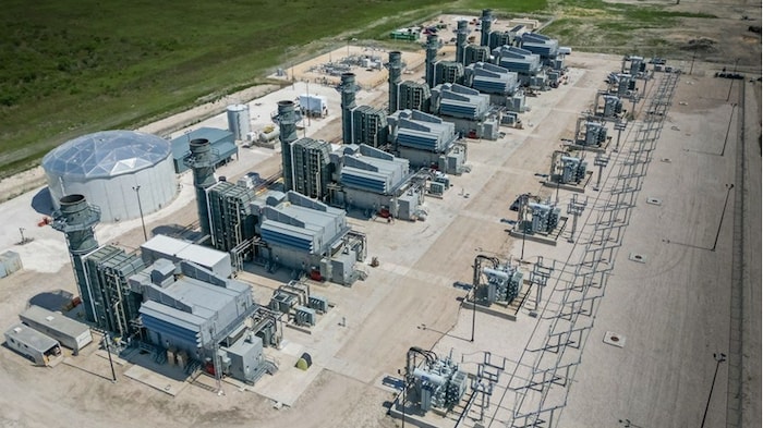 Sept turbines sur un site recouvert de béton.