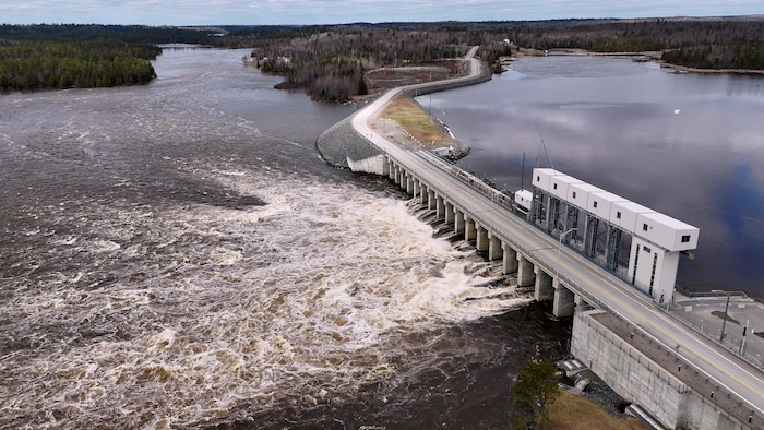 Des images prises par un drone montrent l'eau du lac des Quinze traverse un barrage dans le secteur d'Angliers, au Témiscamingue. La route 391 traverse une forêt.