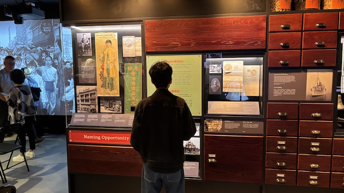Un homme est debout devant des tiroirs dans un musée.