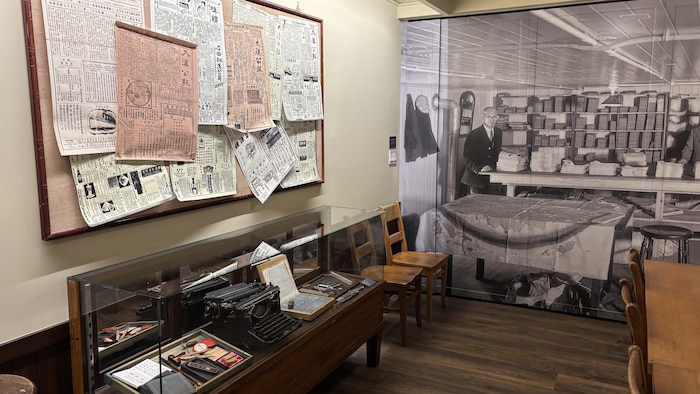 Une salle de musée expose de vieilles affiches ainsi qu'une machine à écrire.