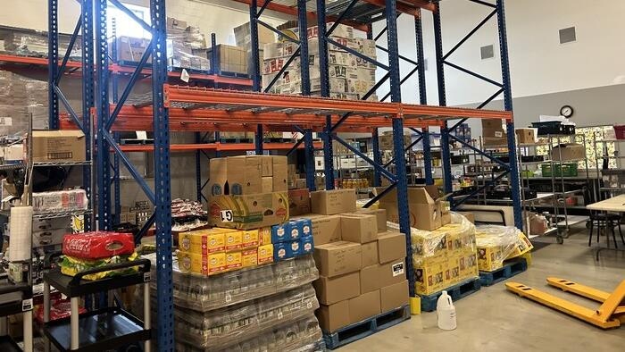 Des tablettes dans un entrepôt, certaines son vides.