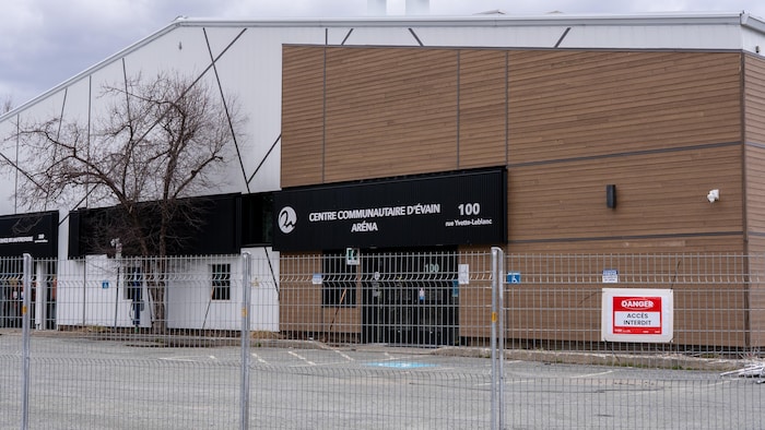 Un panneau sur une clôture indique que l'accès au bâtiment est interdit.
