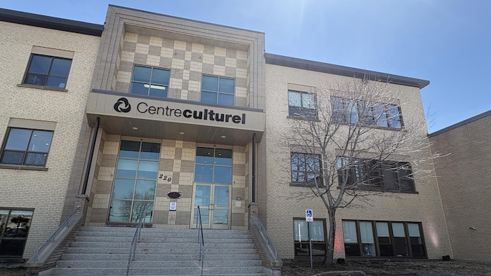 Un édifice de briques beiges avec un lettrage qui indique qu'il s'agit d'un centre culturel sur le devant.