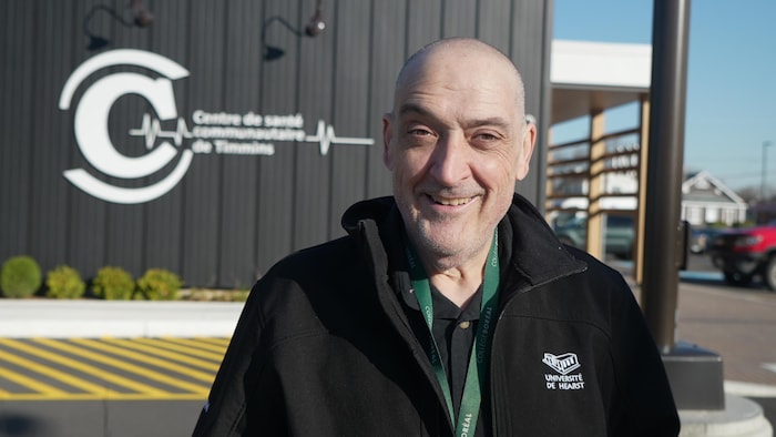 Un homme se tient devant le Centre de santé. 