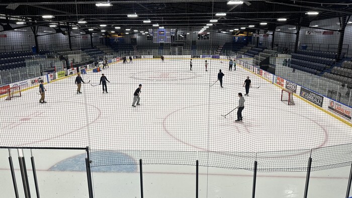 Des gens jouent au hockey dans un aréna.
