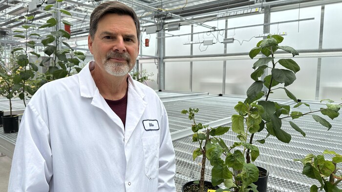 Mike Rott devant des plantes.