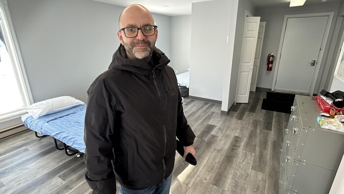 Un homme dans une petite salle avec des lits.
