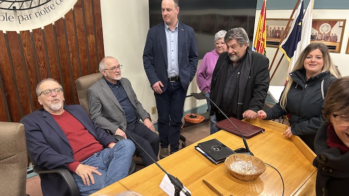 Un groupe de personnes en discussion autour d'une table.