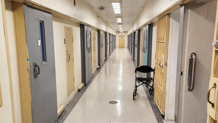 Un couloir avec des cellules de prison.