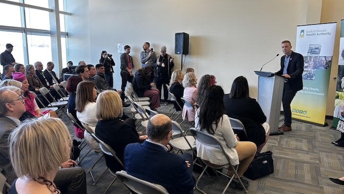 Jeremy Cockrill dans une pièce qui parle à un micro devant des personnes assises.