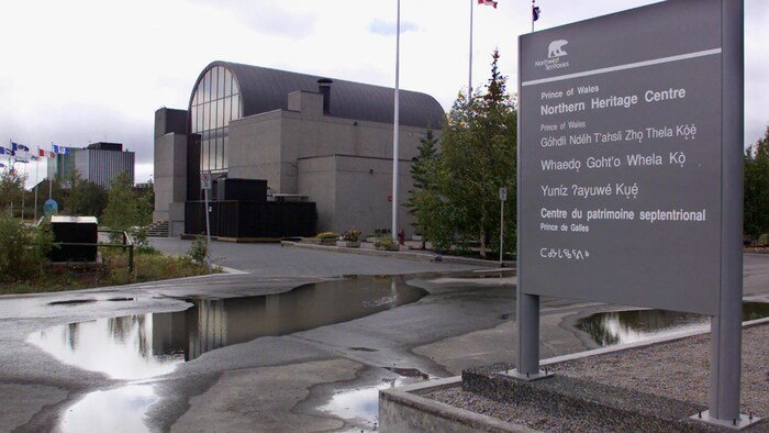 L'entrée à l'extérieur du Centre du patrimoine septentrional Prince-de-Galles dont la pancarte s'affiche en anglais, en français, en inuktitut et d'autres langues des Premières Nations.