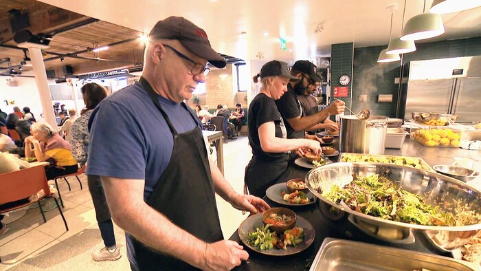Des bénévoles préparent des repas dans la cuisine du centre Sumac.