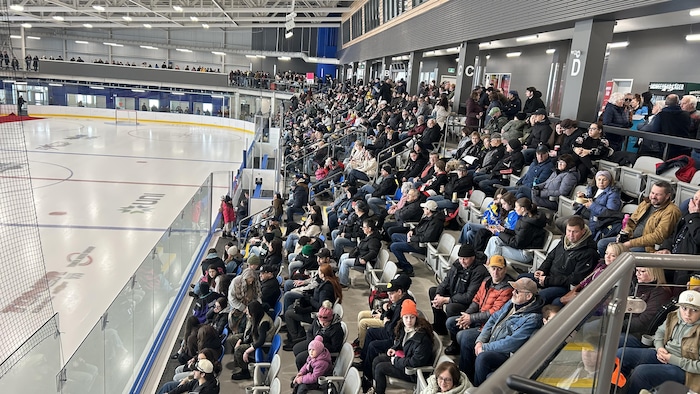 Des personnes rassemblées dans un aréna.