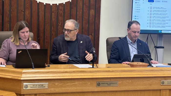 Trois personnes assises à une table.