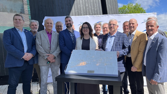 Les conseillers municipaux et la mairesse dévoilent une maquette du centre-ville.