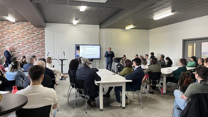 Des personnes réunies dans une salle de rencontre.
