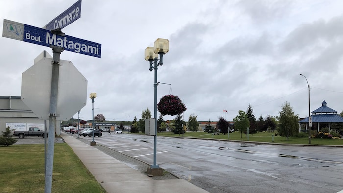La photo a été prise à l'angle de la rue du Commerce et le boulevard Matagami. Des voitures sont stationnées au loin devant les commerces.