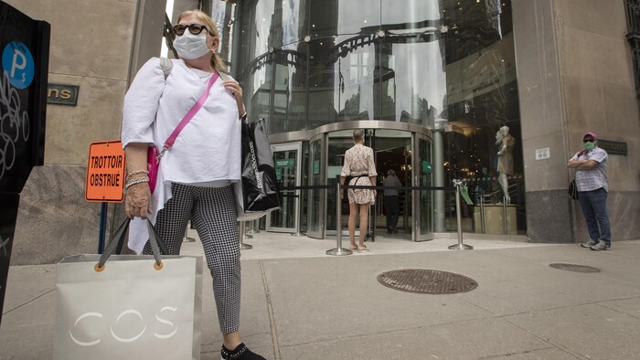 Une femme pose avec un sac devant le magasin Simons au centre-ville de Montréal.