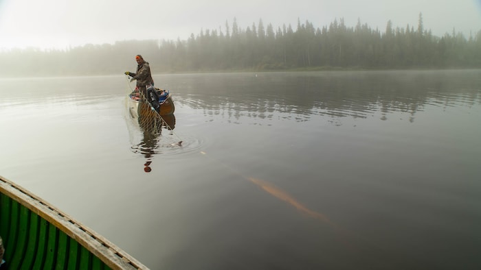 Un membre de Neskantaga relève un filet de pêche.