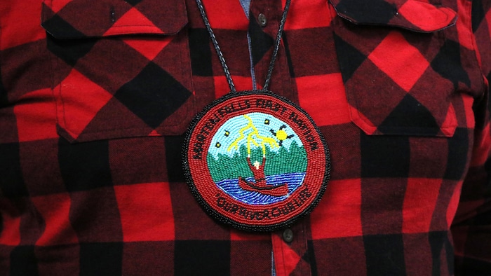 Un médaillon où est écrit «Marten Falls First Nation» et «Our stream our life».