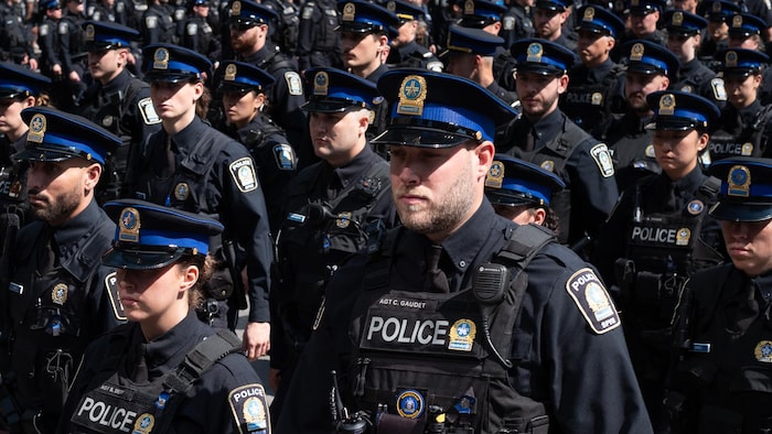 Des policiers en uniforme placés en rangs.
