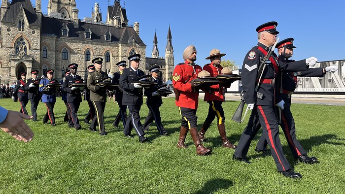 Des policiers marchent sur la colline du Parlement, à Ottawa, avec des chapeaux de policiers pour représenter ceux qui sont morts au cours de la dernière année.