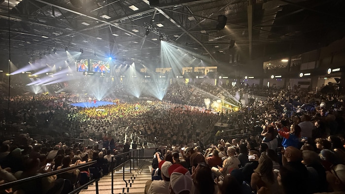 Des milliers de personnes sont rassemblés dans un amphithéâtre.