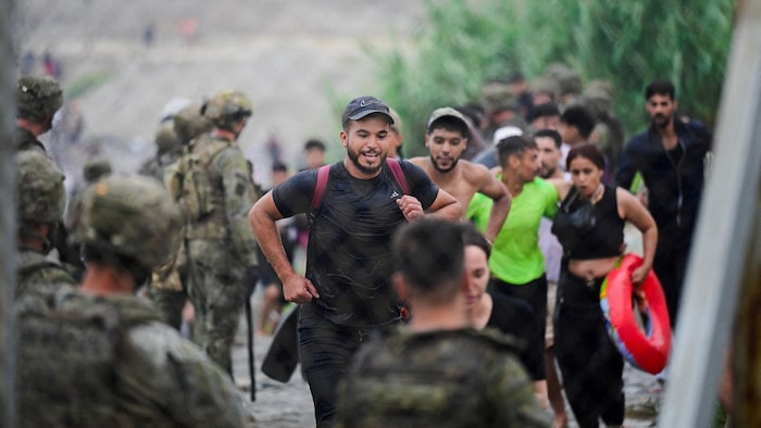 Des migrants arrivent devant des gardes à la frontière espagnole.