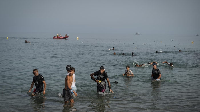 Des migrants arrivent sur la plage de Tarajal après avoir franchi la frontière entre l'Espagne et le Maroc le 31 juillet 2026 à Ceuta, en Espagne. 