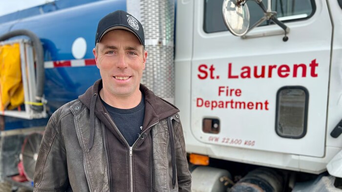 Chad Malfait devant un camion du Service de lutte contre les incendies de la MR de Saint-Laurent.