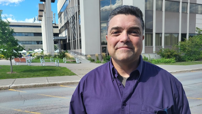 Patrick Faubert prend la pose devant l'UQAC. 