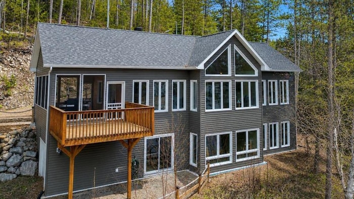 Façade d'un grand chalet à deux étages.