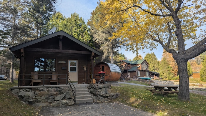 Un petit chalet en bois et un sauna extérieur.