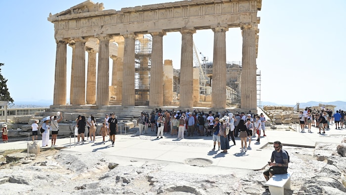 Des touristes cherchent de l'ombre.
