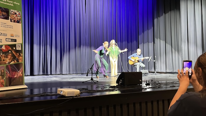 Il y a une chanteuse, une danseuse de flamenco et un guitariste sur scène.