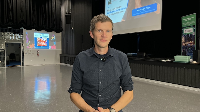 Un homme se tenant dans une salle de spectacle.