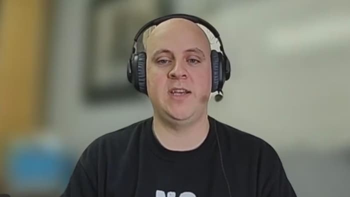 Joël Castonguay en entrevue par visioconférence, portant un casque d'écoute.