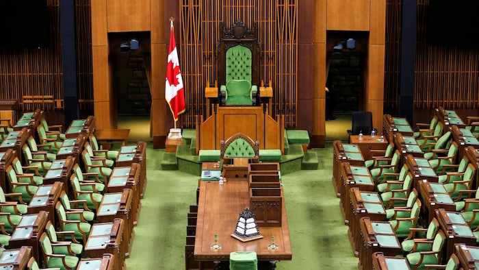 قاعة مجلس العموم الكندي في أوتاوا ويبدو فيها العلم الكندي بجانب كرسي رئيس المجلس.