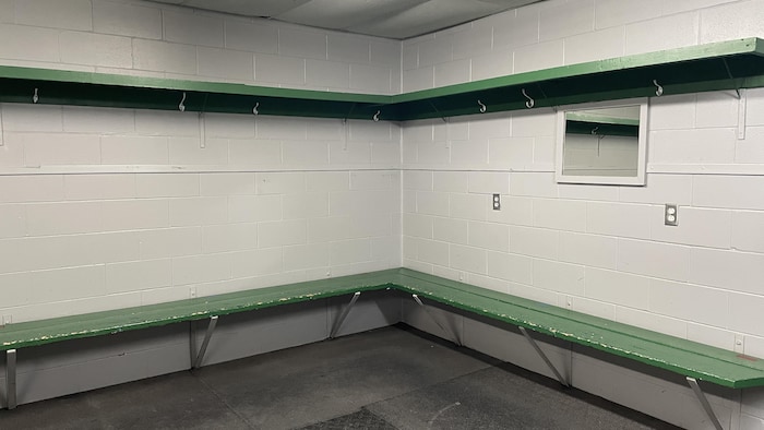 Une chambre des joueurs dans laquelle les bancs montrent des signes d'usure.