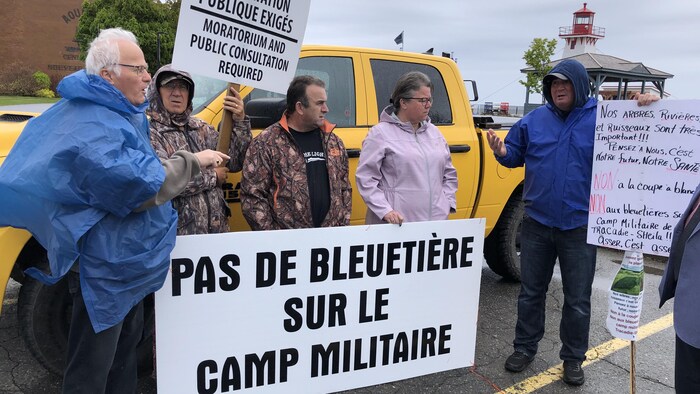 Des manisfestants tiennent des affiches.