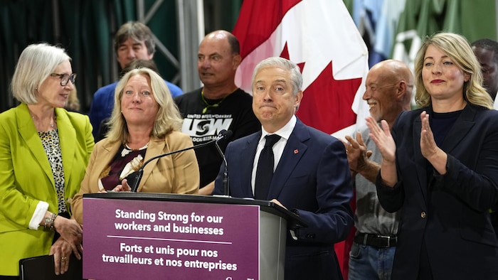 François-Philippe Champagne derrière un lutrin dans les locaux d'une entreprise de toiture à Ottawa.