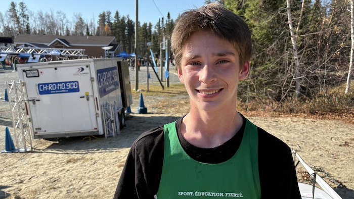 Un adolescent souriant et portant un dossard de la région.