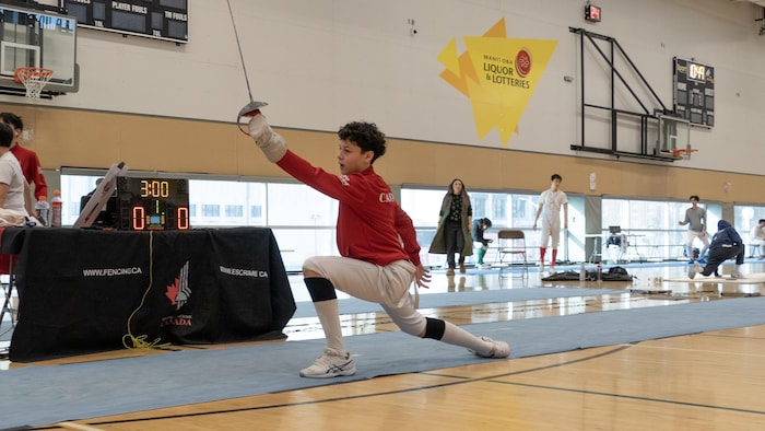 Un jeune escrimeur lève son sabre, le 16 février 2025 à Winnipeg.