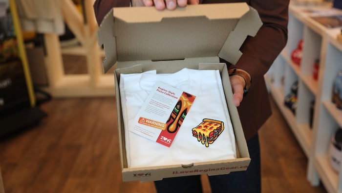 Un chandail promotionnel de la Ville de Regina sur lequel on retrouve un dessin de pizza, en août 2026.