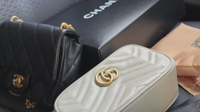 Un sac griffé Chanel, un sac griffé Gucci et leur emballage respectif sur une banquette d'auto. 