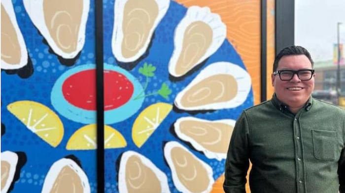 Dylan Rose pose devant une murale. 