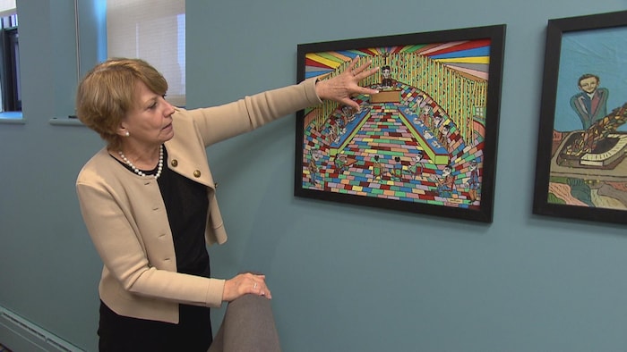 Une femme pointe quelque chose sur un tableau.