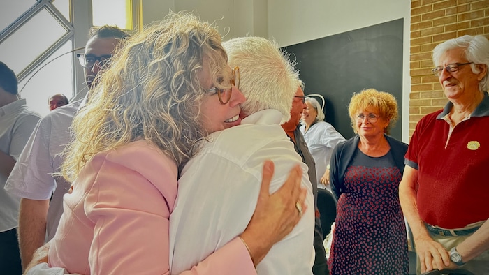 Chantale Marchand serre un homme âgé dans ses bras.